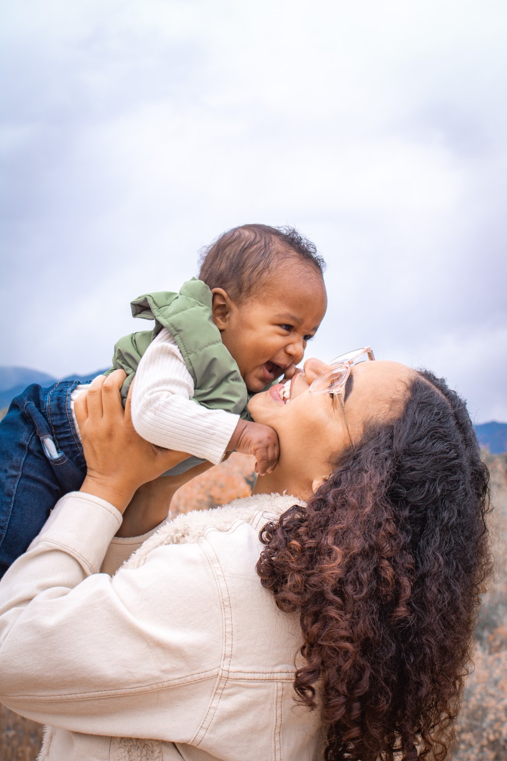 A mother lifting her smiling baby