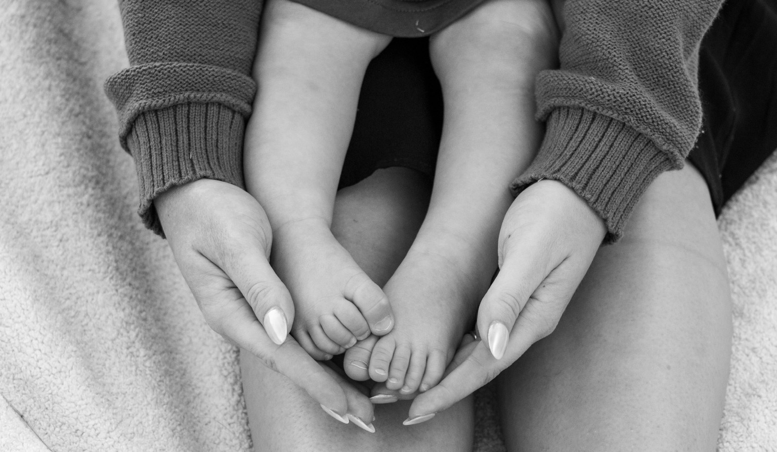 Tiny feet cradled in gentle hands