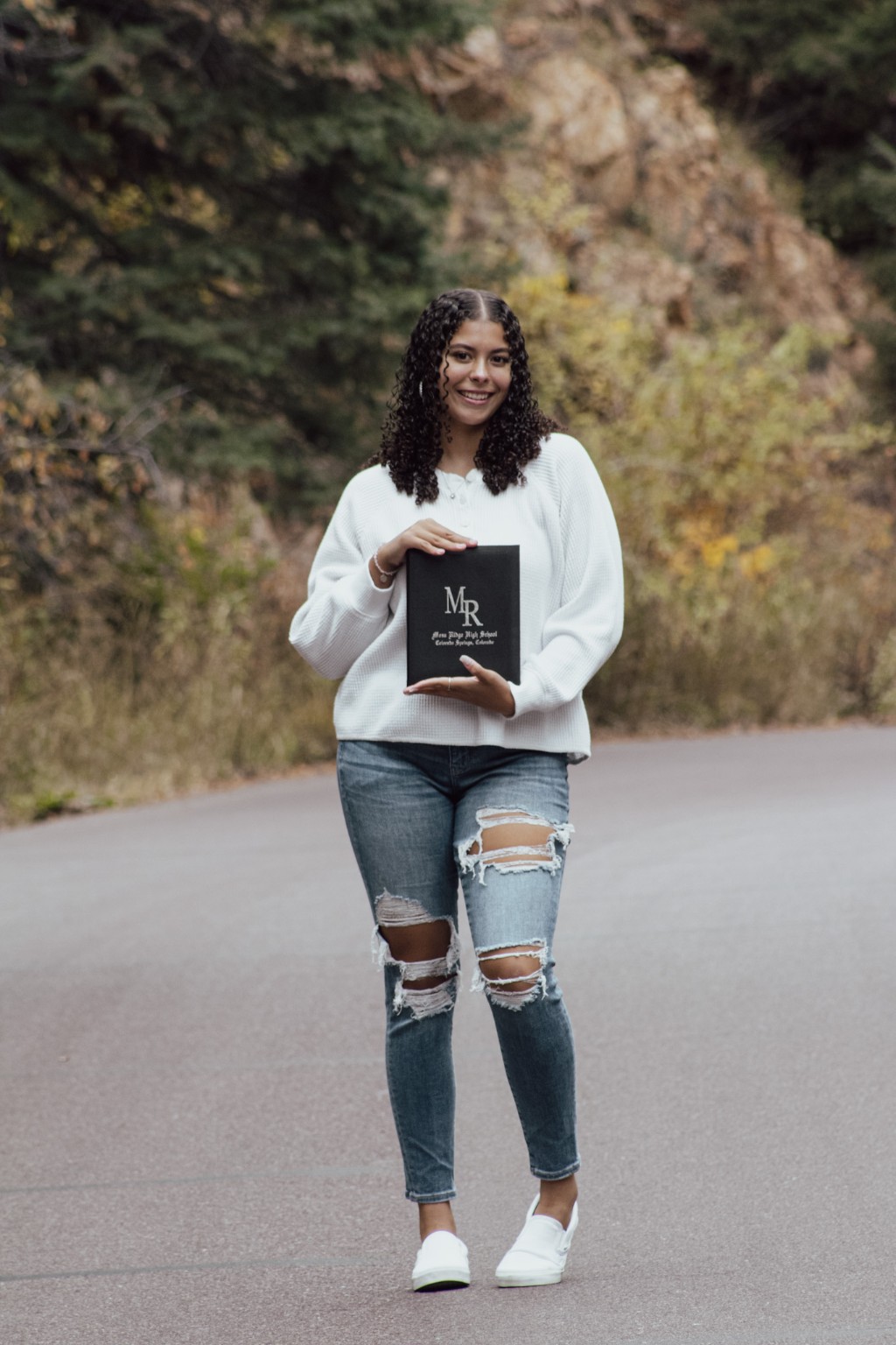 A graduate holding her diploma